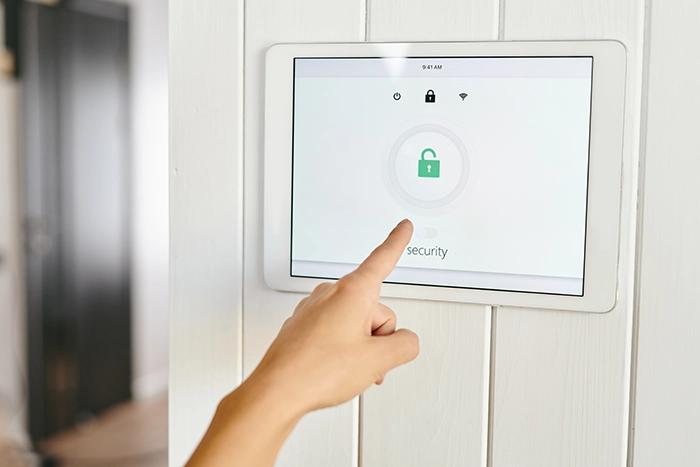Screen mounted on wall with person pressing home security button