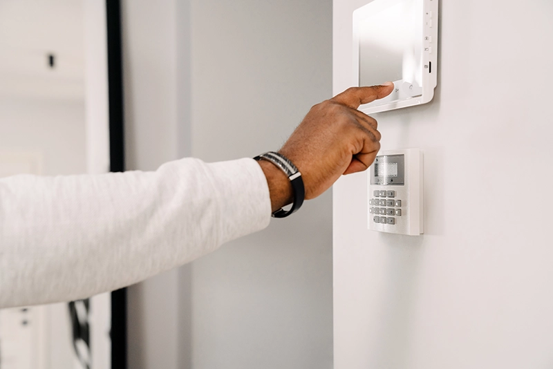 Hand operating a wall mounted modern security panel